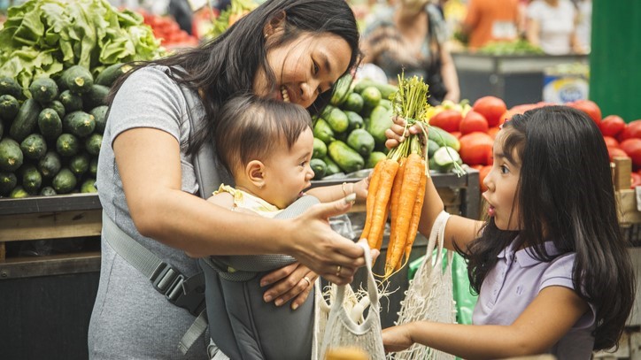 — title missing — Mother and children in produce section of grocery store