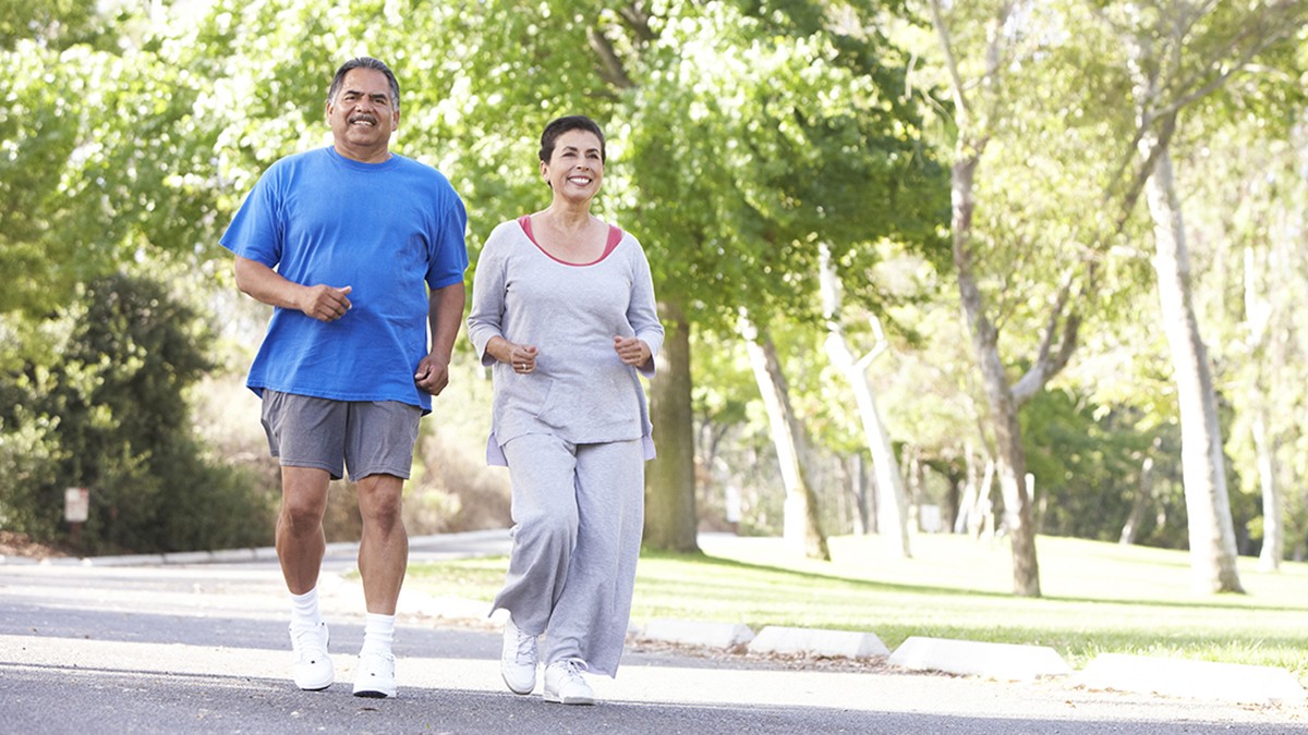 Una pareja de mediana edad corriendo en el parque.