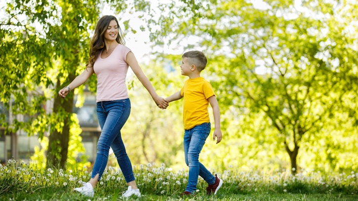 Mother and son walking in a park.